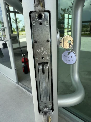 Top pivot bearing on aluminum storefront door showing wear that causes door to sag and misalign with lock strike